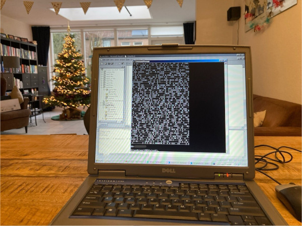 Photo of an old laptop
running Windows XP and Visual Studio showing debug output of an Advent
of Code solution. Christmas decoration in the background.